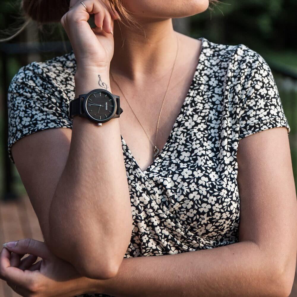 young lady wearing a wooden watch from GoWood, with cases made entirely of black sandalwood and a real cork wristband