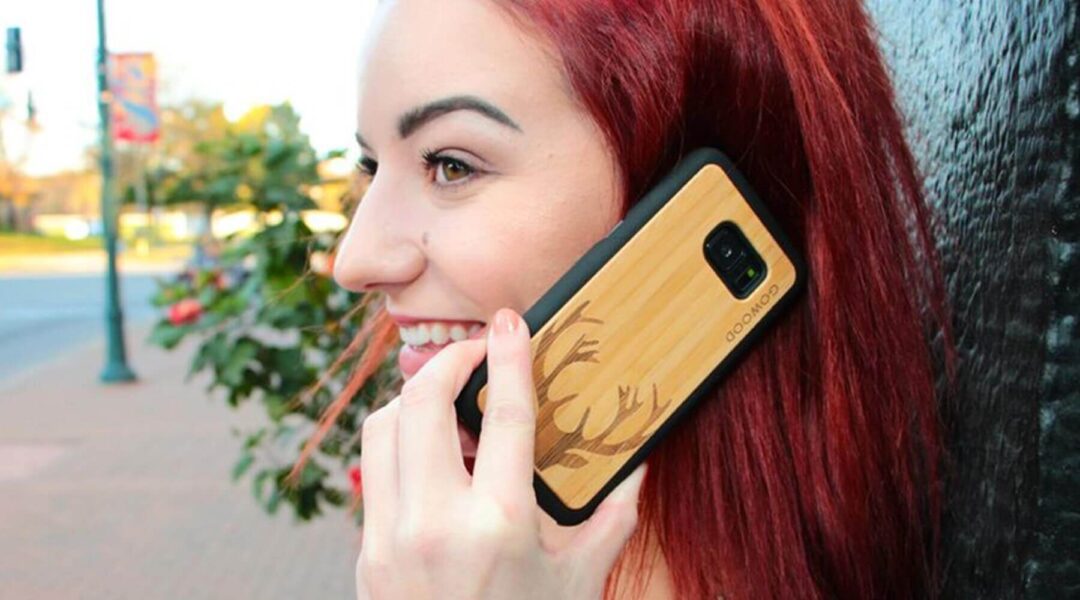 young lady with red hair talking on her phone with a Gowood wooden phone case on it