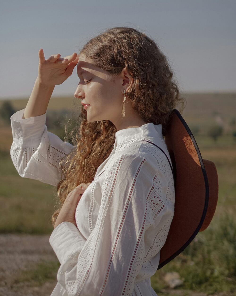 A woman shields her eyes from bright sun, reminding us to prevent sunburned eyes