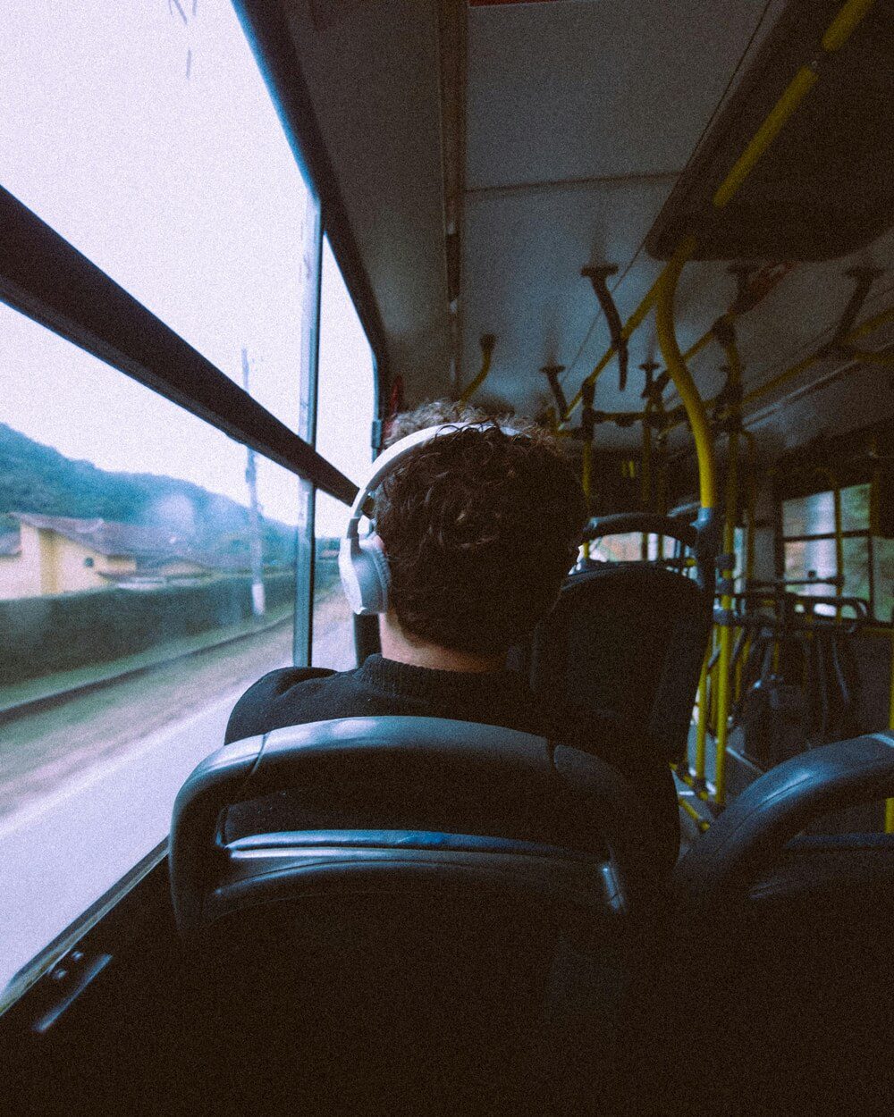 Photo of a young man listening to music on a bus ride